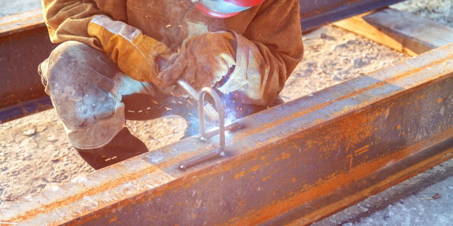 Skilled worker welding a steel structure, representing personnel supply for construction projects